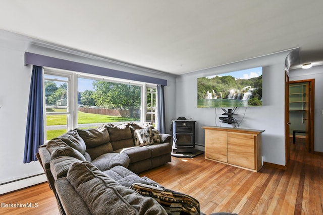 68 Tower Rd, Dalton, MA 01226 - living area with a baseboard heating unit, a wood stove, and light wood-style flooring
