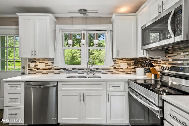 68 Tower Rd, Dalton, MA 01226 - kitchen featuring stainless steel appliances, backsplash, white cabinetry, ornamental molding, and decorative light fixtures