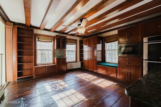 interior space with built in microwave, dark hardwood / wood-style flooring, radiator, beamed ceiling, and stainless steel double oven