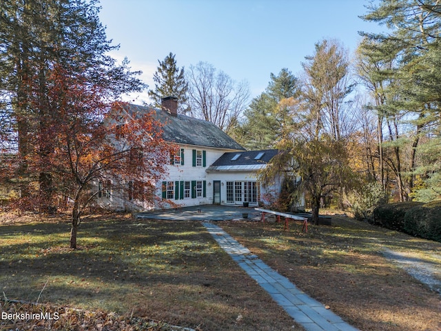 view of front of home featuring a front lawn and a patio