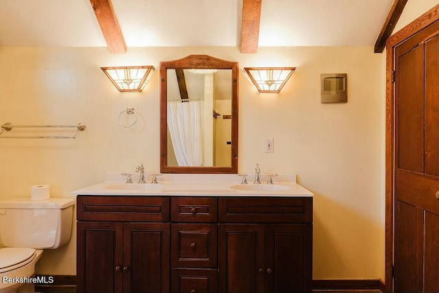 bathroom featuring vanity, toilet, and beamed ceiling