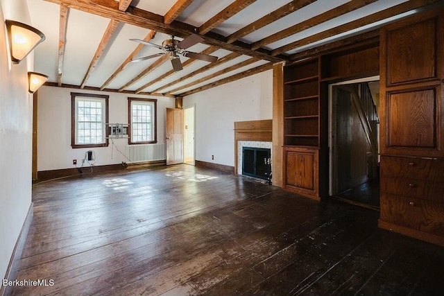 unfurnished living room featuring dark hardwood / wood-style floors, radiator heating unit, built in features, lofted ceiling with beams, and ceiling fan