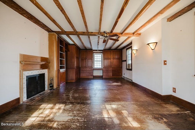 unfurnished living room featuring ceiling fan, a baseboard heating unit, beam ceiling, dark hardwood / wood-style flooring, and built in shelves