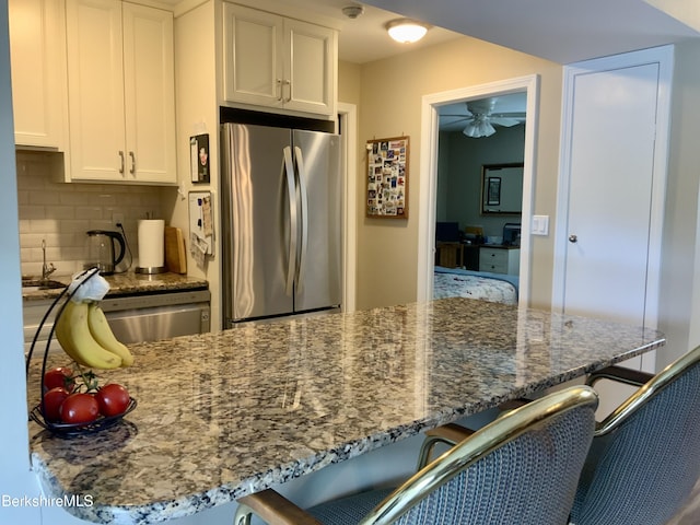 9 Rolling Hls Unit 5, Lenox, MA 01240 - kitchen featuring appliances with stainless steel finishes, a breakfast bar area, ceiling fan, and decorative backsplash