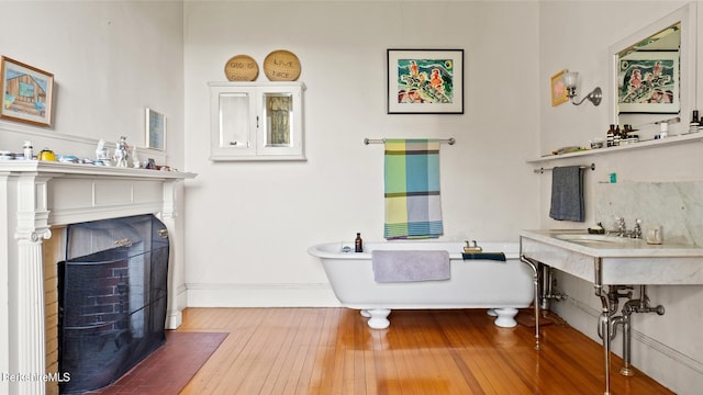 bathroom featuring hardwood / wood-style floors, a bath, and sink