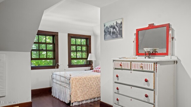 bedroom with dark wood-type flooring and vaulted ceiling