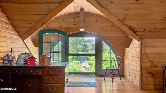 interior space with wooden walls, light hardwood / wood-style flooring, wood ceiling, and lofted ceiling