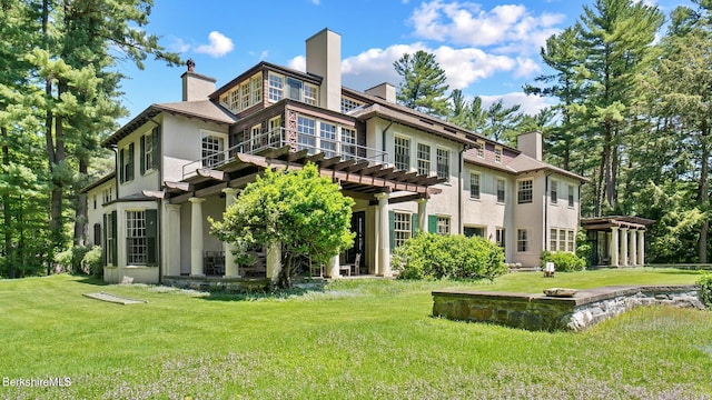 rear view of house with a pergola and a lawn