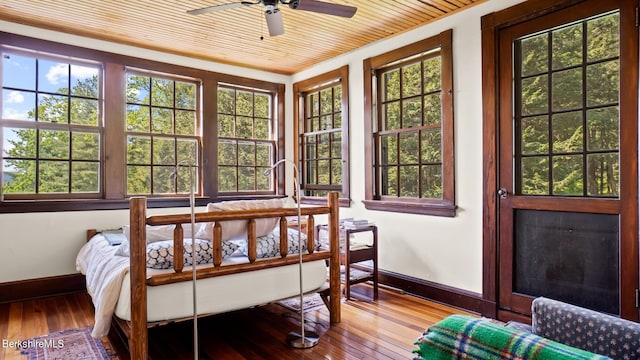 sunroom with ceiling fan and wooden ceiling