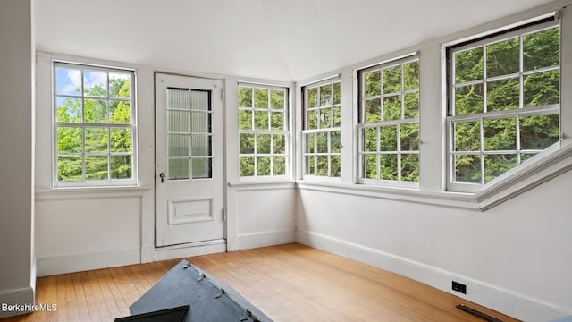 unfurnished sunroom featuring a healthy amount of sunlight and vaulted ceiling