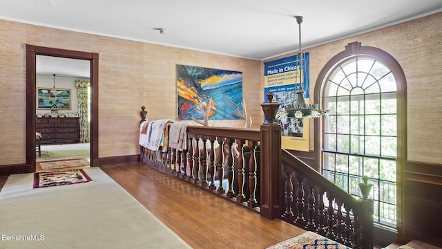 bedroom featuring hardwood / wood-style flooring, ornamental molding, and a nursery area