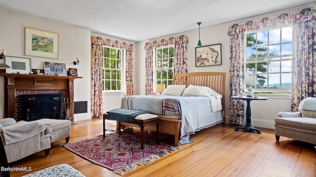 bedroom with a fireplace and hardwood / wood-style floors