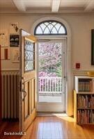 entryway with crown molding, radiator, wood finished floors, beamed ceiling, and coffered ceiling