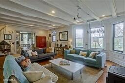 living area featuring recessed lighting, beam ceiling, and wood finished floors