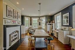 dining space featuring recessed lighting, dark wood-style flooring, crown molding, and a fireplace
