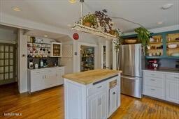 kitchen with light countertops, a center island, freestanding refrigerator, and wood finished floors