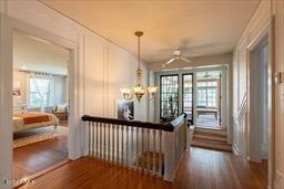 hall featuring an inviting chandelier and dark wood-style floors
