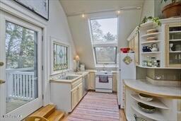 kitchen featuring light countertops, plenty of natural light, open shelves, and oven
