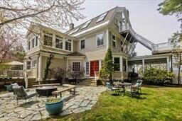 back of house featuring a patio, an outdoor living space with a fire pit, and a yard
