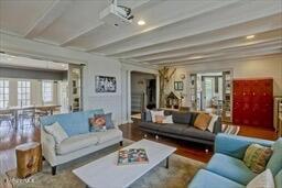 living area featuring plenty of natural light, wood finished floors, and beamed ceiling