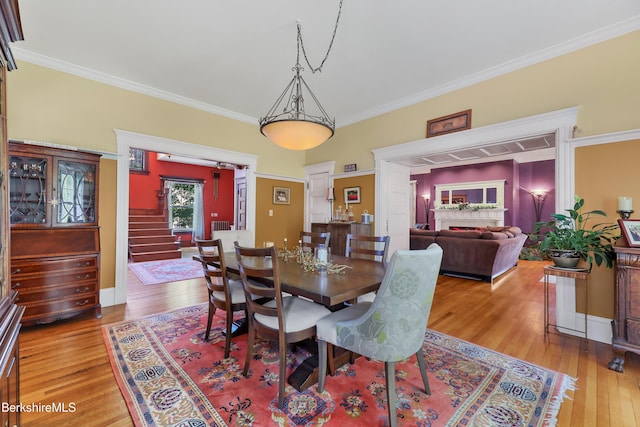 dining space with stairway, ornamental molding, and wood finished floors