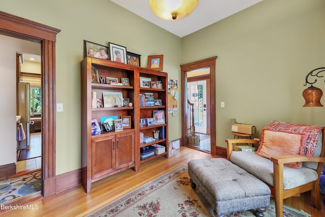 sitting room with baseboards and light wood-style flooring