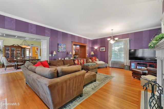 living area featuring a chandelier, ornamental molding, wood finished floors, and radiator