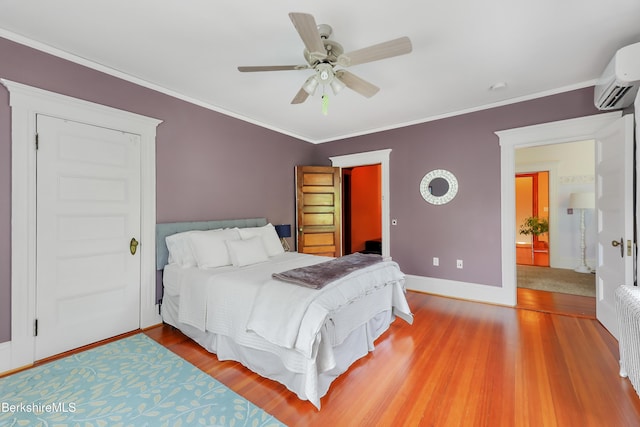 bedroom with crown molding, baseboards, a wall mounted air conditioner, and light wood-type flooring