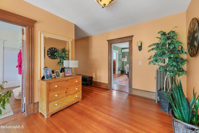 interior space featuring a wall mounted air conditioner and light wood-type flooring