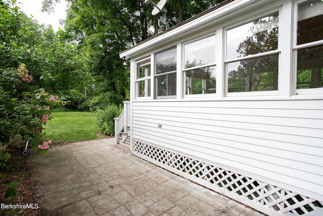 view of home's exterior with a patio area and a yard