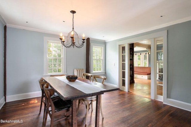 dining area with dark hardwood / wood-style flooring, ornamental molding, and an inviting chandelier