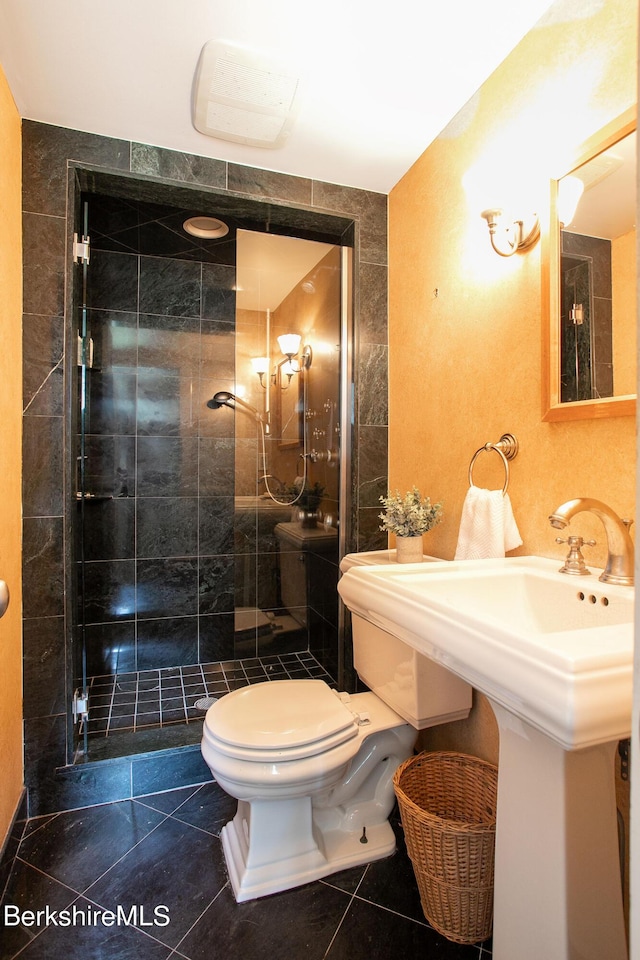 bathroom featuring toilet and a shower with door