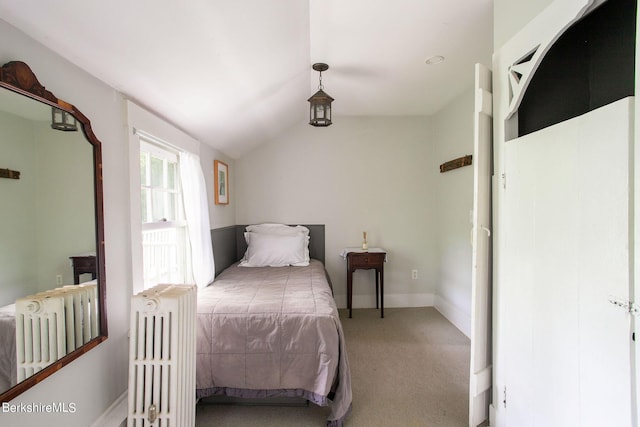 bedroom featuring carpet flooring, radiator, and vaulted ceiling