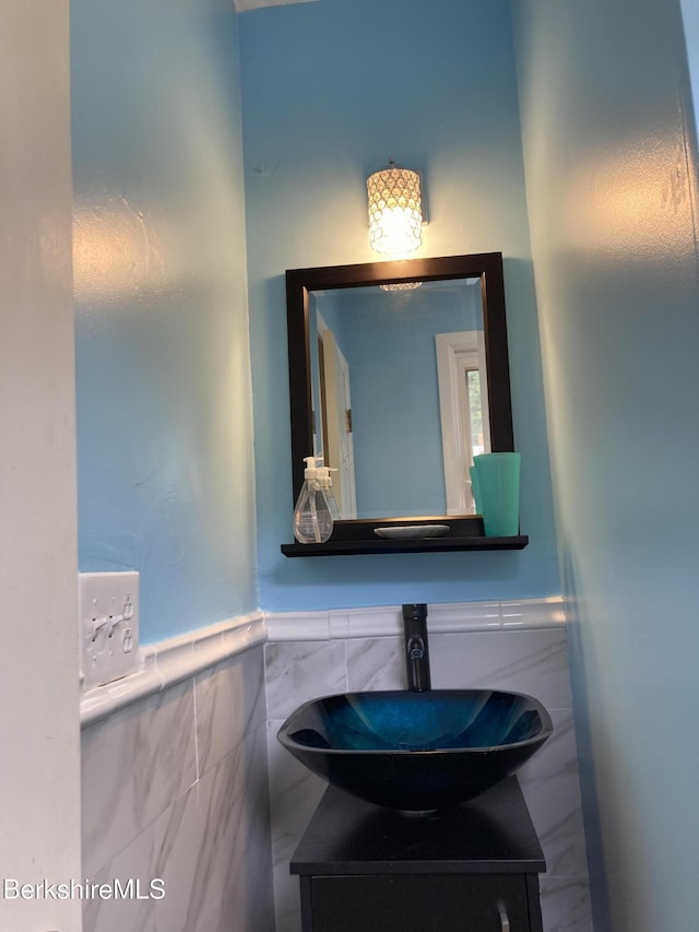 bathroom featuring tile walls, vanity, and a wainscoted wall