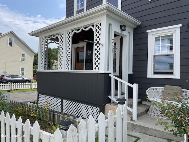 view of property exterior with fence and covered porch