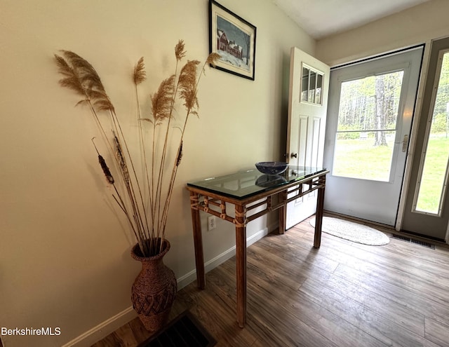 doorway to outside with baseboards and wood finished floors