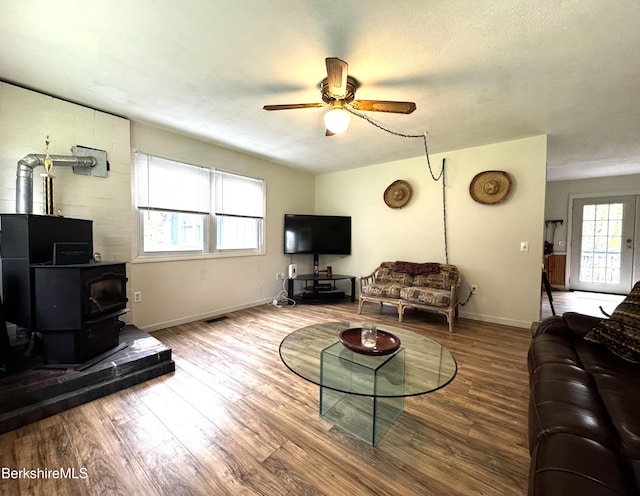 732 Main St, Becket, MA 01223 - living room with a wood stove, a ceiling fan, wood finished floors, and baseboards