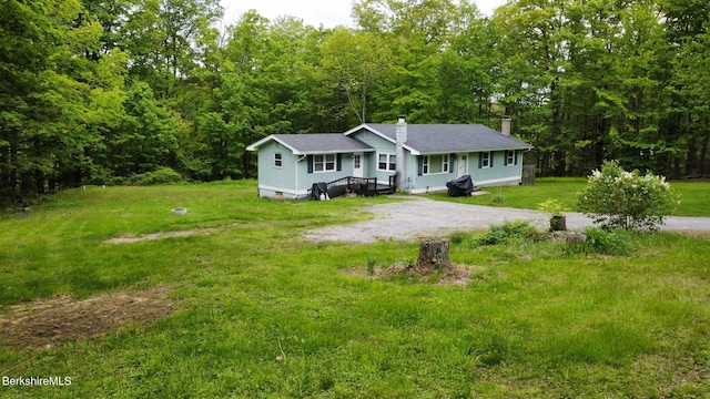 732 Main St, Becket, MA 01223 - view of front of home with a chimney, a wooded view, driveway, a front lawn, and roof with shingles