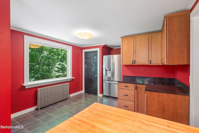 kitchen featuring radiator heating unit, stainless steel refrigerator with ice dispenser, and ornamental molding