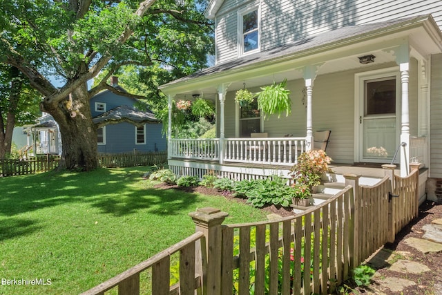 exterior space featuring covered porch and a yard