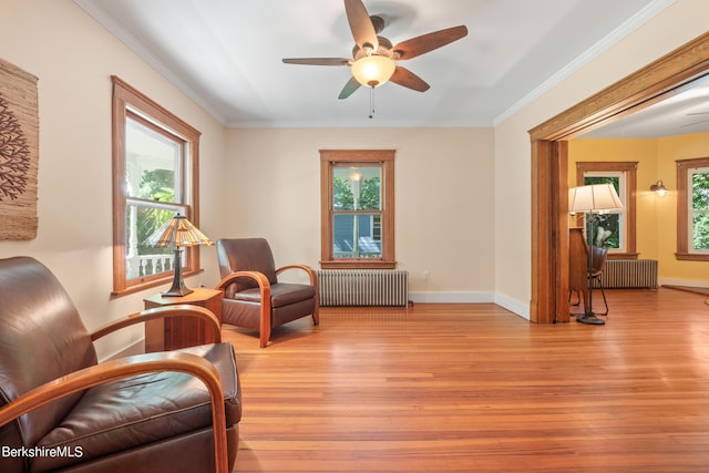 sitting room featuring radiator, a wealth of natural light, and ceiling fan