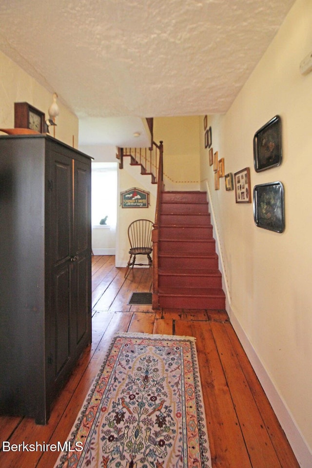 196 Huntington Rd, Worthington, MA 01098 - hallway with a textured ceiling, hardwood / wood-style flooring, and stairway
