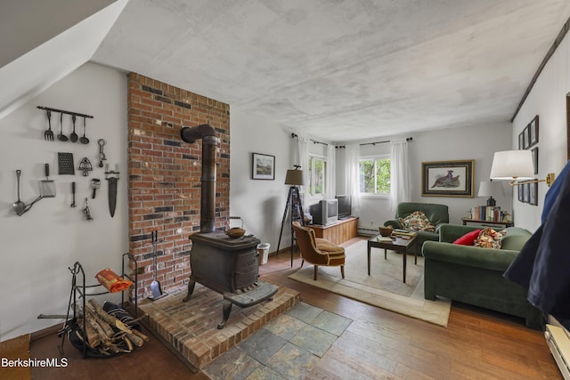 203 Main St, Hancock, MA 01237 - living room featuring wood-type flooring, a wood stove, and a baseboard radiator
