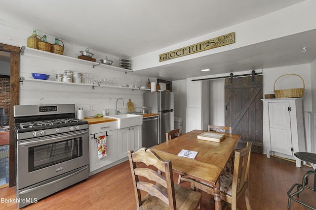 203 Main St, Hancock, MA 01237 - kitchen with stainless steel appliances, a barn door, a sink, light wood-style floors, and open shelves