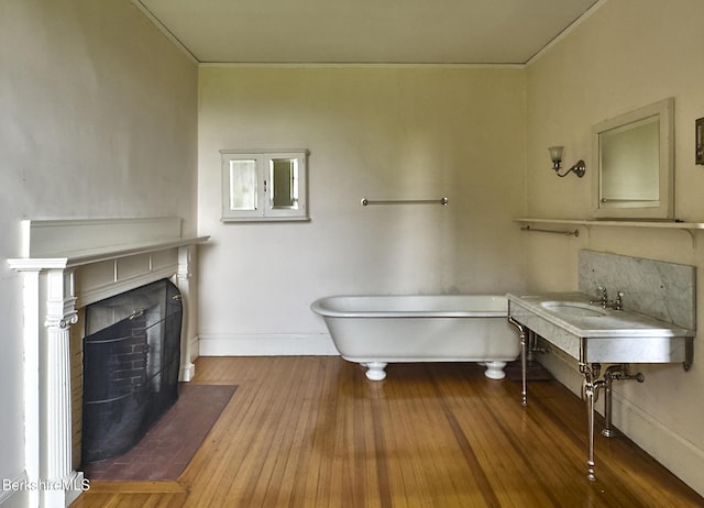 319 Under Mountain Rd, Lenox, MA 01240 - bathroom with a freestanding bath, ornamental molding, wood-type flooring, and a fireplace with flush hearth