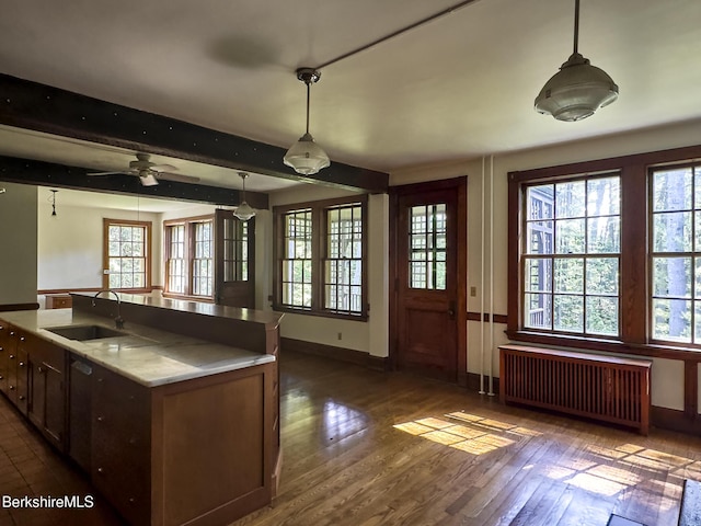 319 Under Mountain Rd, Lenox, MA 01240 - kitchen with radiator heating unit, dark wood-type flooring, hanging light fixtures, an island with sink, and beamed ceiling