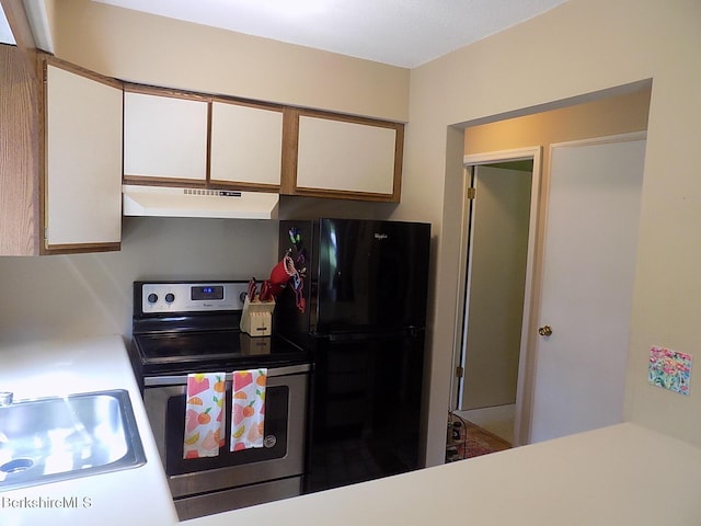 880 E St Unit 1A, Lee, MA 01238 - kitchen featuring under cabinet range hood, electric stove, freestanding refrigerator, white cabinets, and a sink