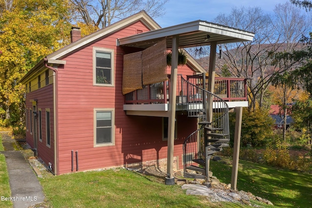 back of property featuring a lawn and a deck