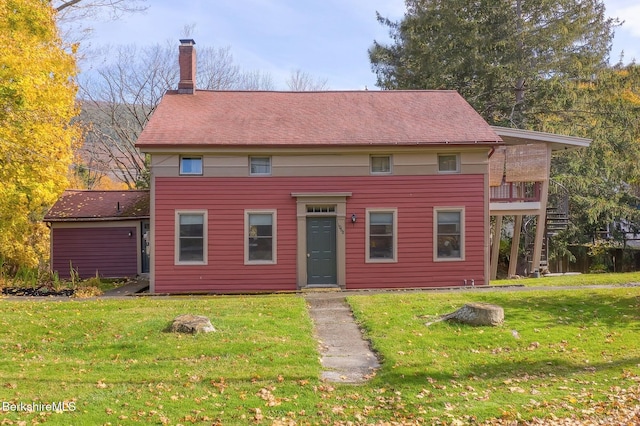 view of front facade featuring a balcony and a front yard