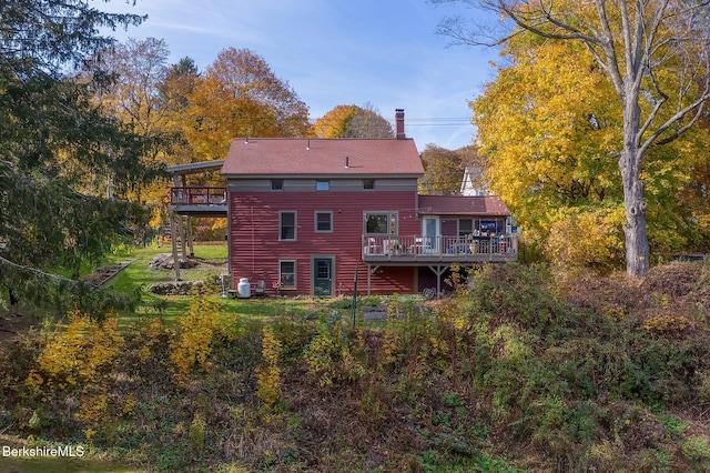 rear view of house featuring a wooden deck